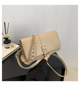 Dettaglio borsa a tracolla beige con manico intrecciato e fibbia quadrata