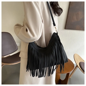 Close-up of black fringe hobo bag with long tassels and gold zipper hardware