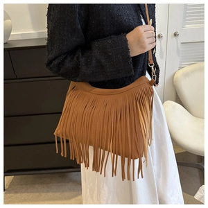 Caramel fringed shoulder bag featuring long tassels and gold metal hardware detailing