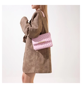 Side view of pink chevron quilted shoulder bag with gold chain strap on model