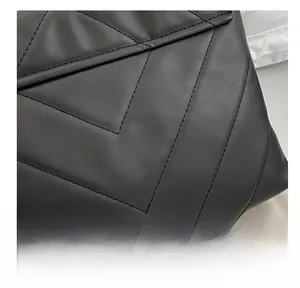 Close-up of quilted black leather texture with V-shaped cross stitching on shoulder bag