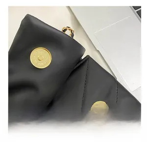 Macro detail of the golden magnetic buckle and quilted leather on this black shoulder bag