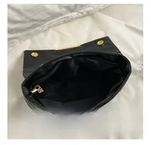 Interior view of black faux leather shoulder bag with gold zipper and main compartment