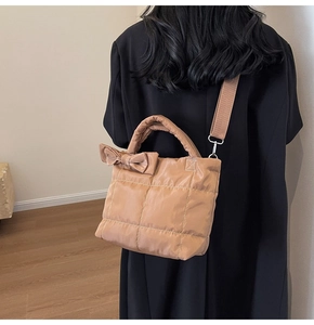 Detailed back view of a khaki quilted tote bag featuring a large decorative side bow