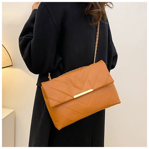 Detail of caramel chevron quilted shoulder bag with gold chain and metal clasp closure