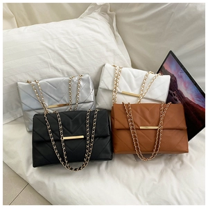Detail view of quilted cross-body bags in silver, white, black and brown with gold chains