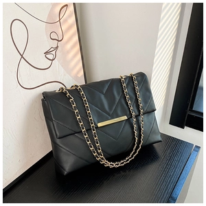 Detail of black V-quilted shoulder bag with gold metal clasp and chain strap