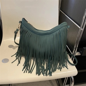 Deep green faux leather tote bag with bohemian tassels and gold-tone hardware detail
