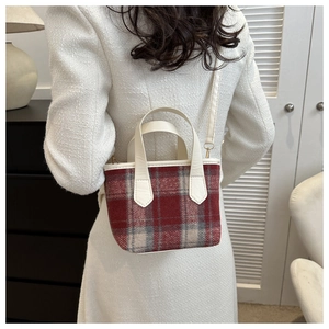 Close-up of vintage red plaid bucket bag with premium leather handles and stitching details