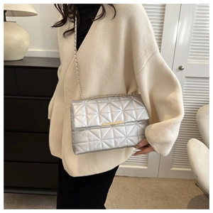 Détail du sac matelassé argenté avec finition métallique et fermoir doré élégant