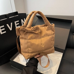 Quilted caramel down tote bag with oversized bow and adjustable crossbody strap