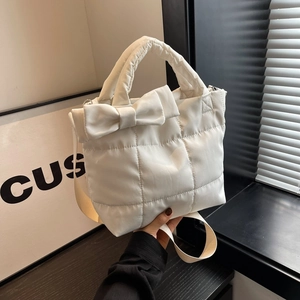 White quilted puffer tote bag with a large bow detail and adjustable shoulder strap