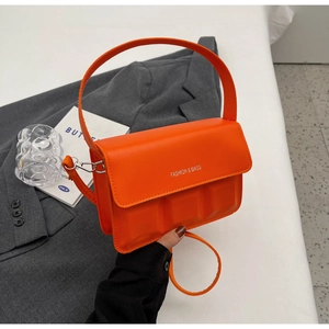 Detail of orange square embossed leather handbag with wide handle and thin strap