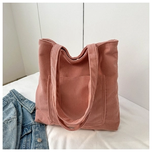 Detail of pink corduroy tote bag featuring vertical texture and front square pocket