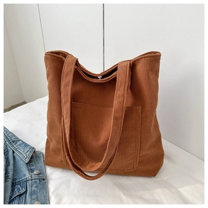 Close-up of brown corduroy tote bag showing vertical texture and magnetic closure