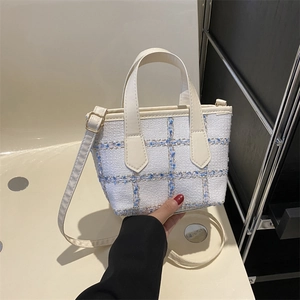 Elegant tweed bucket bag in beige plaid with a chic top handle and adjustable shoulder strap