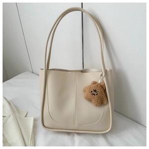 Detail of cream PU leather tote bag with vertical stitching and star plush charm