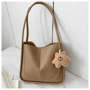 Close-up of brown faux leather tote bag with stylish stitching and a cute star plush charm