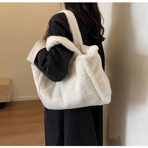 Seitenansicht der weißen Plüschtasche mit weichem Kunstpelz und breitem Schultergurt