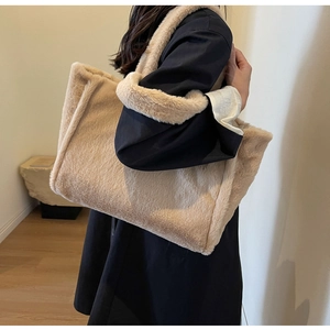 Nahaufnahme einer flauschigen Kunstpelz-Tragetasche in Beige mit breitem Schultergurt