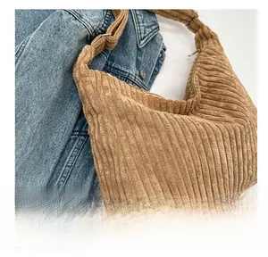 Détail du sac fourre-tout en velours côtelé marron sur une veste en jean bleu