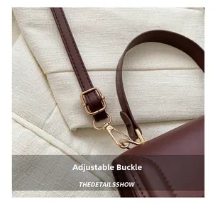Detail of dark brown leather strap with adjustable gold buckle and lobster clasp