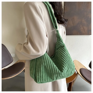 Sac hobo en velours côtelé vert porté à l'épaule montrant la texture et le tombé