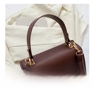 Detail of dark brown leather saddle bag with shiny gold metal ring buckle and hardware