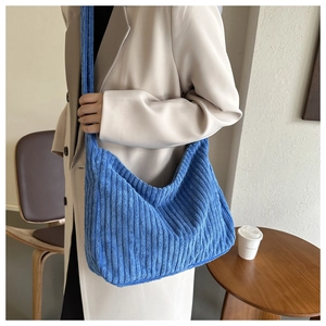 Détail du sac cabas en velours côtelé bleu montrant la texture douce sur le mannequin