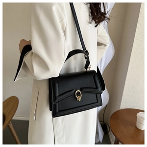 Model wearing a black leather square handbag with golden ring buckle for daily commute