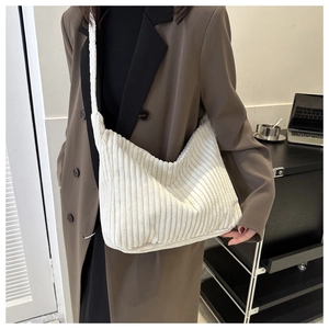 Détail du sac fourre-tout en velours côtelé blanc montrant la texture douce et la bandoulière