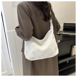 Texture détaillée du sac fourre-tout en velours côtelé blanc porté par un mannequin