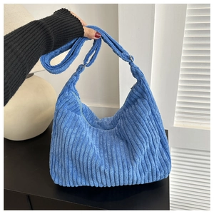 Détail du sac hobo en velours côtelé bleu montrant la texture côtelée et la bandoulière