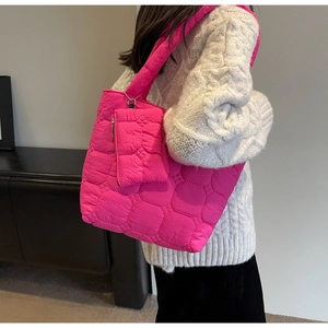 Pink quilted tote bag with matching coin purse shown on a model over the shoulder