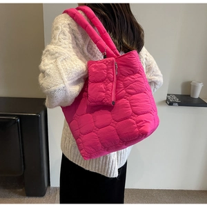 Detail of rose pink quilted tote bag with matching zippered pouch on wide straps