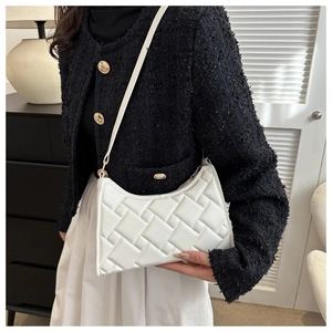 Detail of white woven texture shoulder bag worn with a black and white outfit