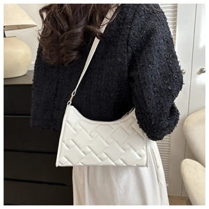 Close-up of the textured geometric woven pattern on the white underarm shoulder bag