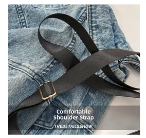 Detail showing comfortable wide nylon strap and gold buckle on blue denim bag