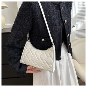 Detail of white quilted underarm bag with thick square weaving and gold hardware details