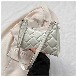 Detail of white quilted leather underarm bag with zipper closure and smooth strap