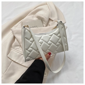 Detail of white quilted faux leather underarm bag with gold hardware and zipper