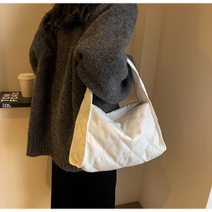 Détail du sac cabas matelassé blanc avec surpiqûres en losange et bandoulière rembourrée