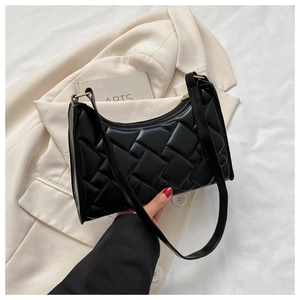 Close-up of black woven texture shoulder bag with golden hardware and zipper detail