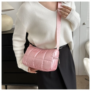 Gros plan du sac à bandoulière matelassé rose au design rembourré avec une large sangle