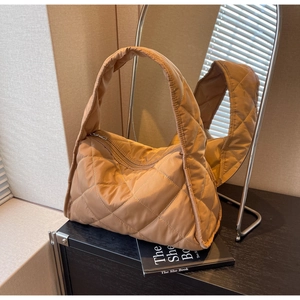 Détail du sac cabas matelassé caramel avec texture brillante et motifs de losanges