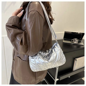 Gros plan sur un sac à bandoulière matelassé argenté brillant à texture rembourrée