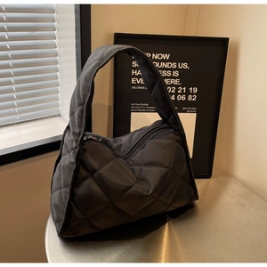 Détail du sac nuage noir matelassé montrant le motif en losange et la fermeture éclair