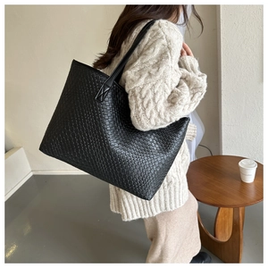 Détail du grand sac cabas noir tressé montrant sa capacité et sa surface texturée