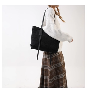 Classic black corduroy tote bag shown on model highlighting the large capacity and texture