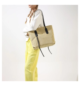 Close-up of beige corduroy tote bag with black straps and vertical ribbed texture